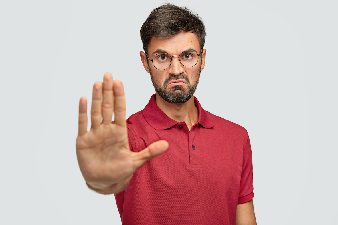 it-s-forbidden-angry-displeased-young-male-frowns-face-shows-stop-gesture-keeps-palm-front-tries-prevent-himeself-from-something-bad-unpleasant-wears-casual-t-shirt-isolated-whitejpg